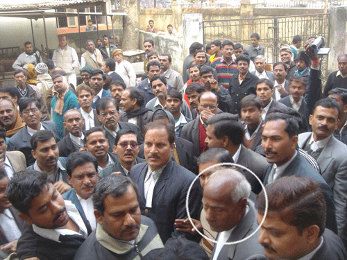 lawyers supporting and opposing (in circle) the exhibition while displaying flex banner