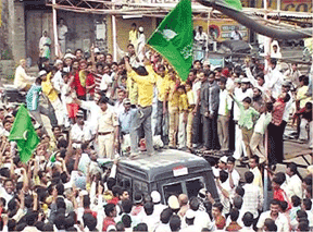 Muslim youth hoisting their green flag on the top of SP’s van at Miraj town