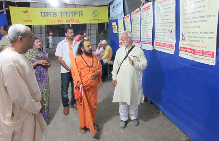 बार्इं ओर से पू. डॉ. चारुदत्त पिंगळे, मध्यभाग में अनंत श्री दंडीस्वामी हेमेंद्रानंद सरस्वती महाराज एवं प्रदर्शनी दिखाते हुए श्री. विनय पानवलकर