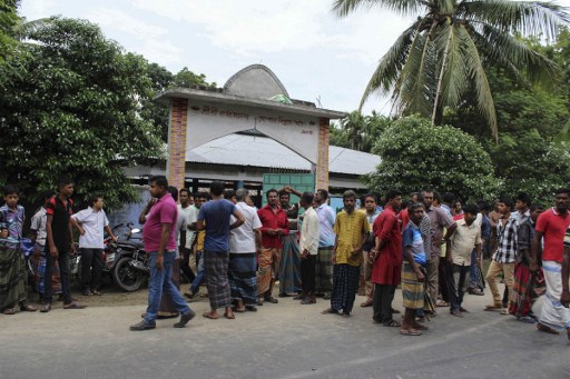 Bystanders gather after Hindu priest Shyamananda Das was hacked to death in Jhenaidah some 211kms north-west of Dhaka on July 1, 2016. A Hindu temple worker was hacked to death in western Bangladesh, police said, the latest in a series of attacks on religious minorities by suspected Islamists. / AFP PHOTO / STR