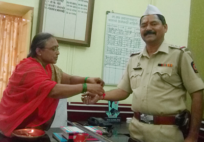 गांधी चौक पुलिस थाने के पुलिस निरीक्षक श्री. गजानन भातलवंडे को राखी बांधते समय श्रीमती अरुणा कुलकर्णी