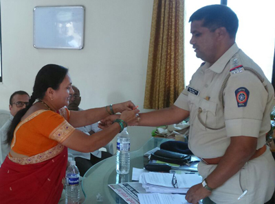 शहर पुलिस थाने के नूतन पुलिस निरीक्षक श्री. विठ्ठल दबडे को राखी बांधते समय श्रीमती अनिता बुणगे