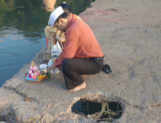 ओंकारेश्‍वर घाट की दुरावस्था में विसर्जन करता हुआ एक भक्त