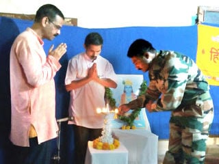 बाईं ओर से श्री. संजय जोशी, श्री. वसंत दळवी तथा दीपप्रज्वलन करते हुए निवृत्त सैनिक लान्सनायक श्री. संदीप कुंभार