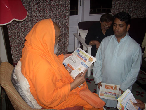 Pujya Swamiji reading 'English Monthly Sanatan Prabhat'