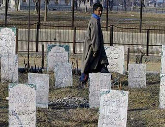 A Kashmiri boy walks through a graveyard in Srinagar.