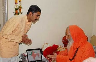 Mr. Hemant Khatri of HJS (at left) showing the Presentation to Pujya Swamiji