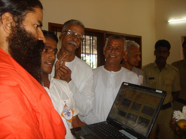 HJS members showing HJS website to H.H. Ramdev Baba