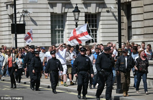 Police officers walk members of the EDL Police officers walk members of the EDL