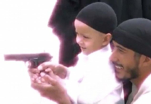 The toddler and the instructor grin as the child is shown how to aim and fire a pistol The toddler and the instructor grin as the child is shown how to aim and fire a pistol