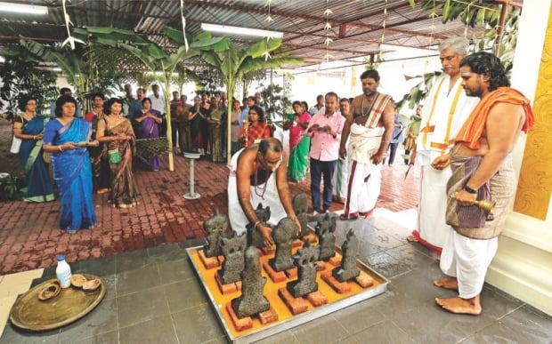 Priests perform prayers before the statues were reinstalled at the Sree Muneeswarar Amman temple