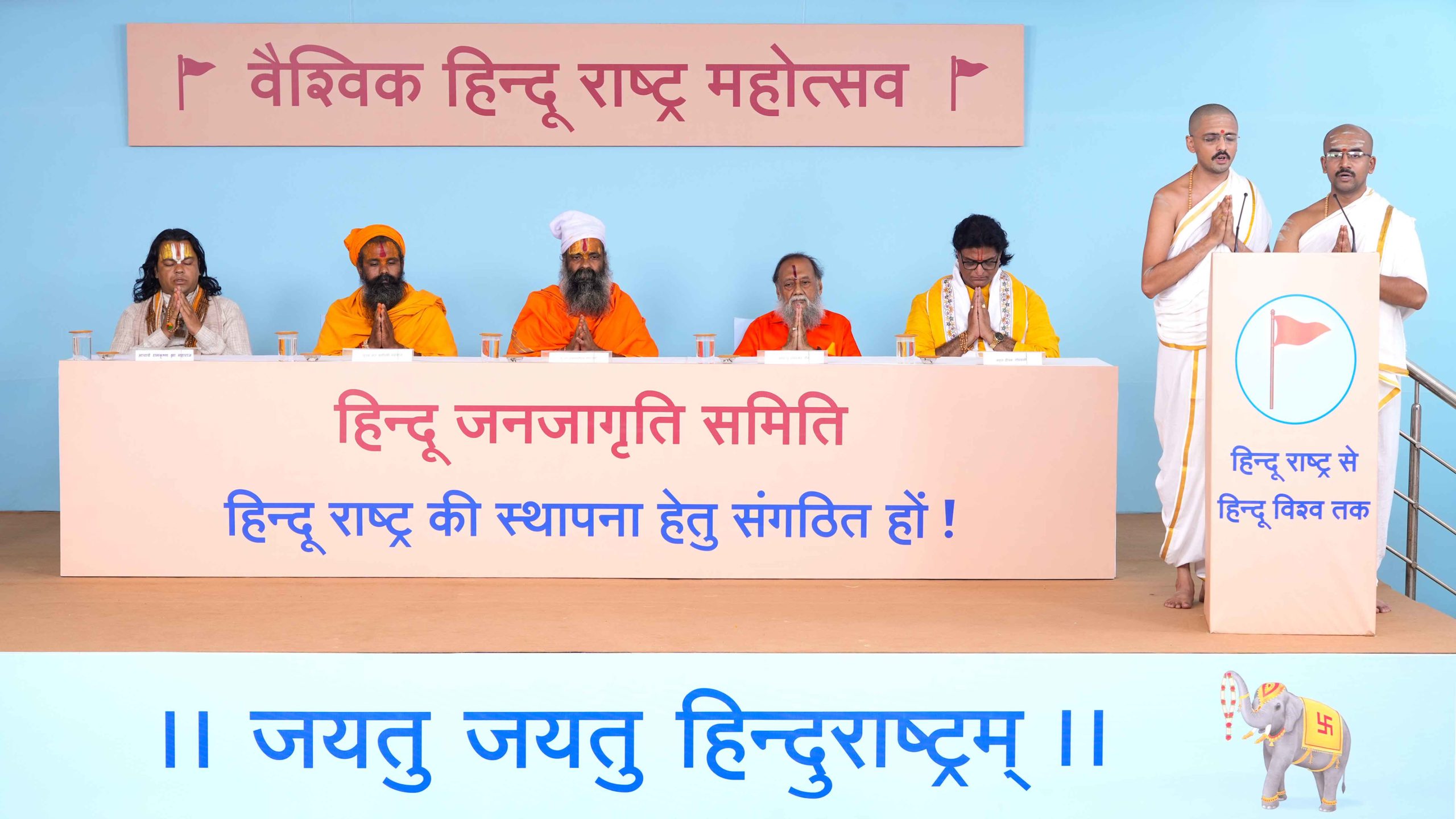 (From left) Shri. Siddhesh Karandikar and Shri. Amar Joshi, priests of Sanatan Purohit Pathshala, reciting Vedamantras for the successful completion of 'Vaishvik Hindu Rashtra Mahotsav', and other Saints on the dais