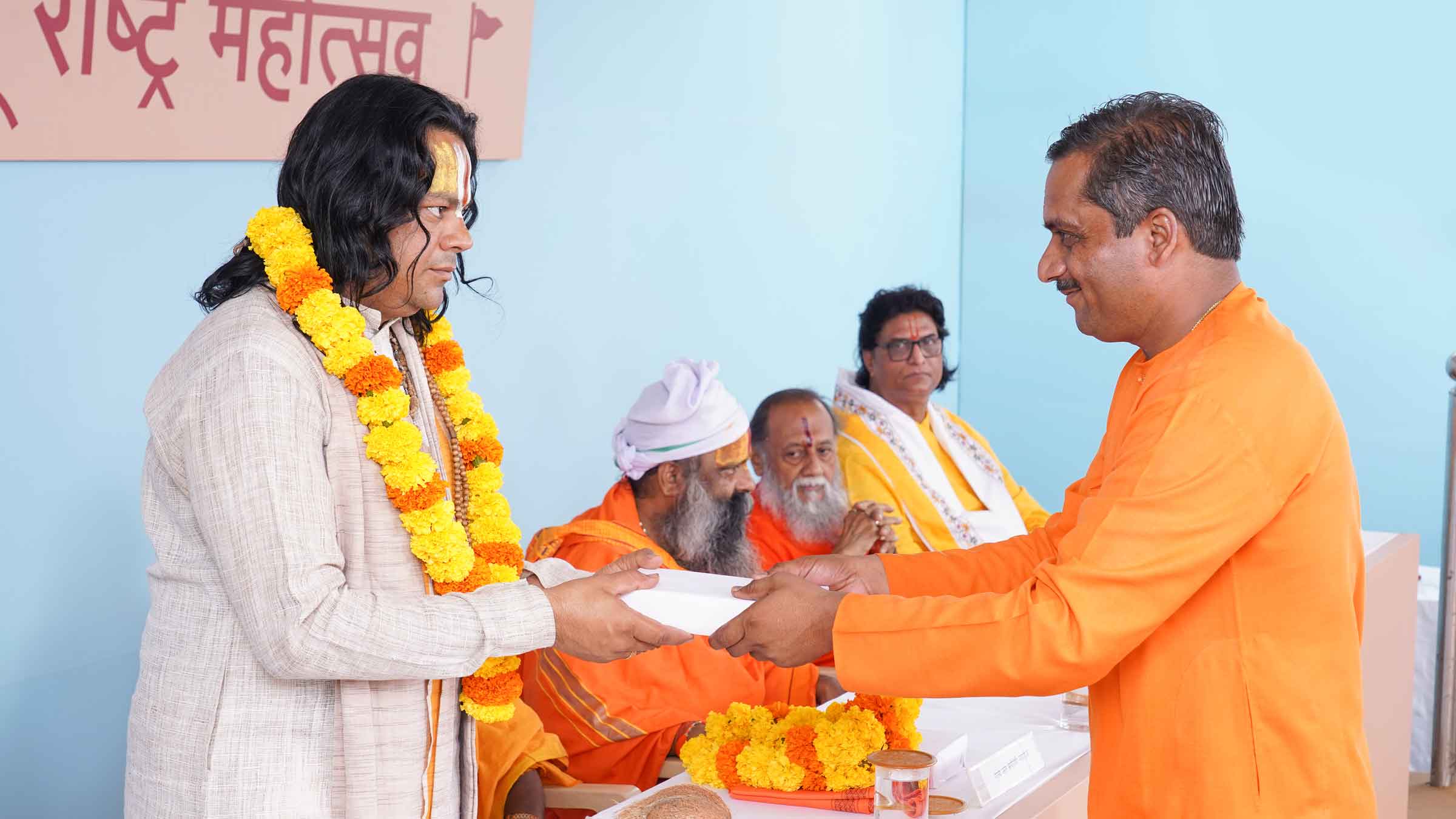 Bhagawatacharya (Adv.) Rajivkrishnaji Maharaj Jha (Founder President, Ramjanaki Seva Samiti and Shyam Sundar Govarshan Gaushala, Dhule, Maharashtra) being felicitated by Mr Rameshwar Bhukan (Hindu Janajagruti Samiti, Nagar, Maharashtra)