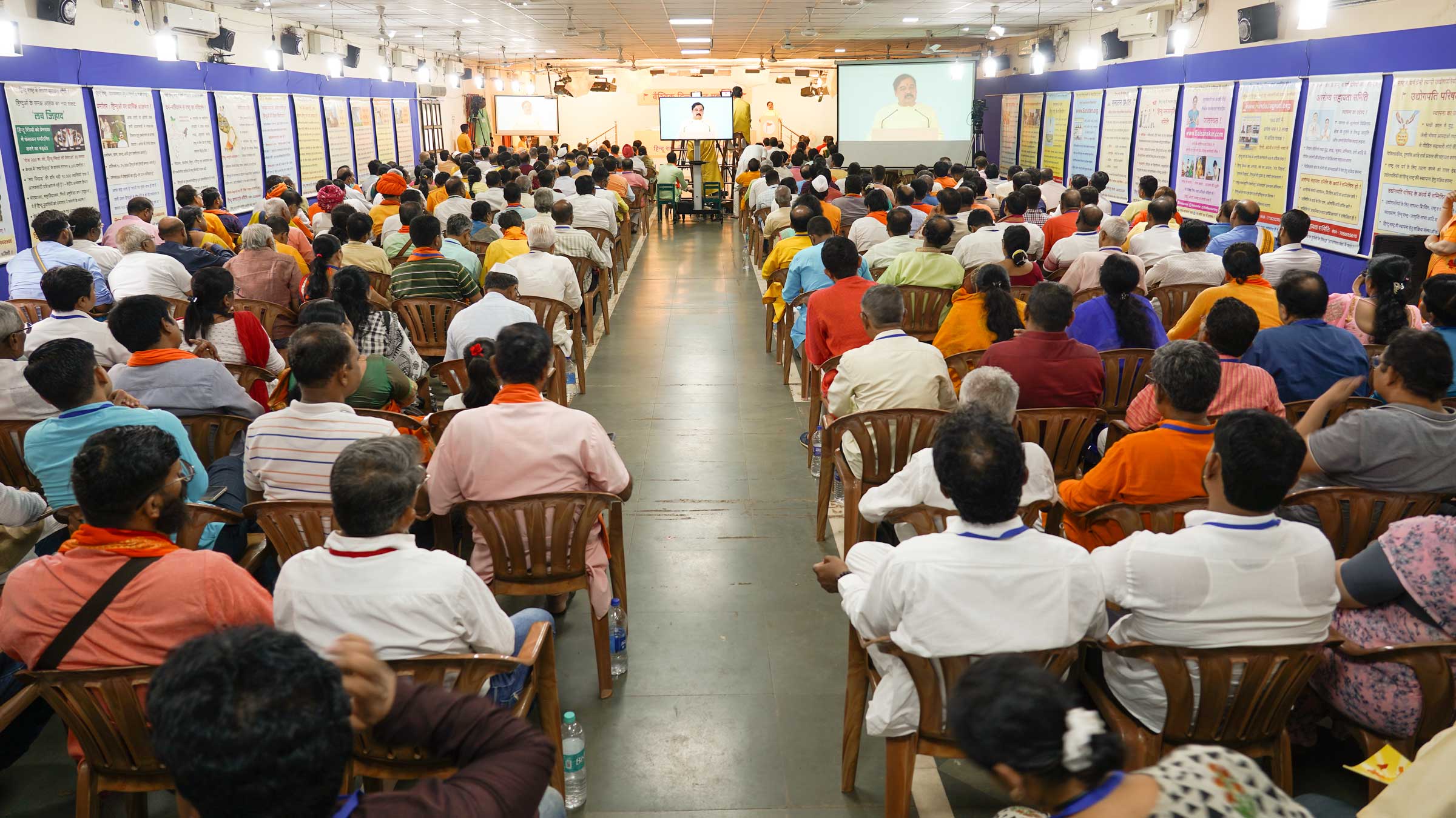 Devout Hindus listening to the speeches of dignitaries being shown through the projector