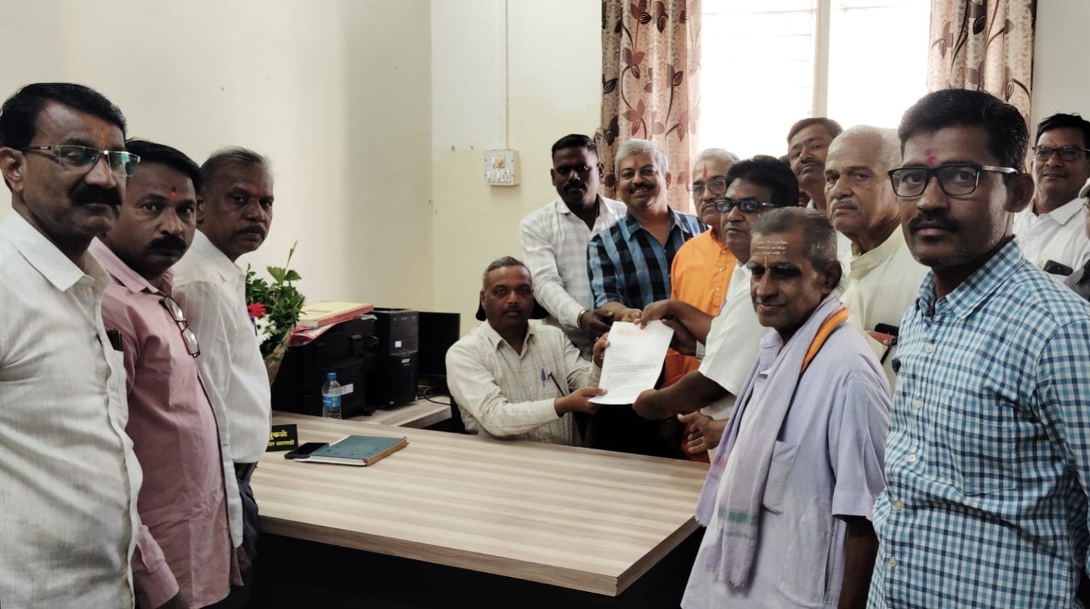 Trustees and representatives of various temples submitting a memorandum to Resident Naib Tehsildar D. S. Pukale (seated) at Atpadi